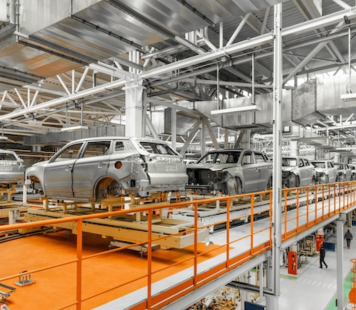 Cars being assembled on an overhead conveyor system in an automobile robotic  factory