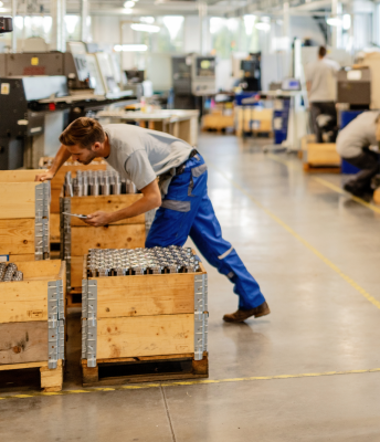 A male worker in the factory gathers and arranges supplies to ensure safe and neat product assembly.