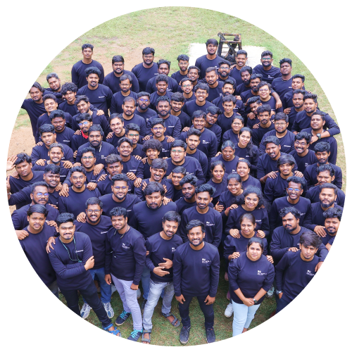 A group of workers in a mobile robot manufacturing facility wearing uniforms posing for pictures.